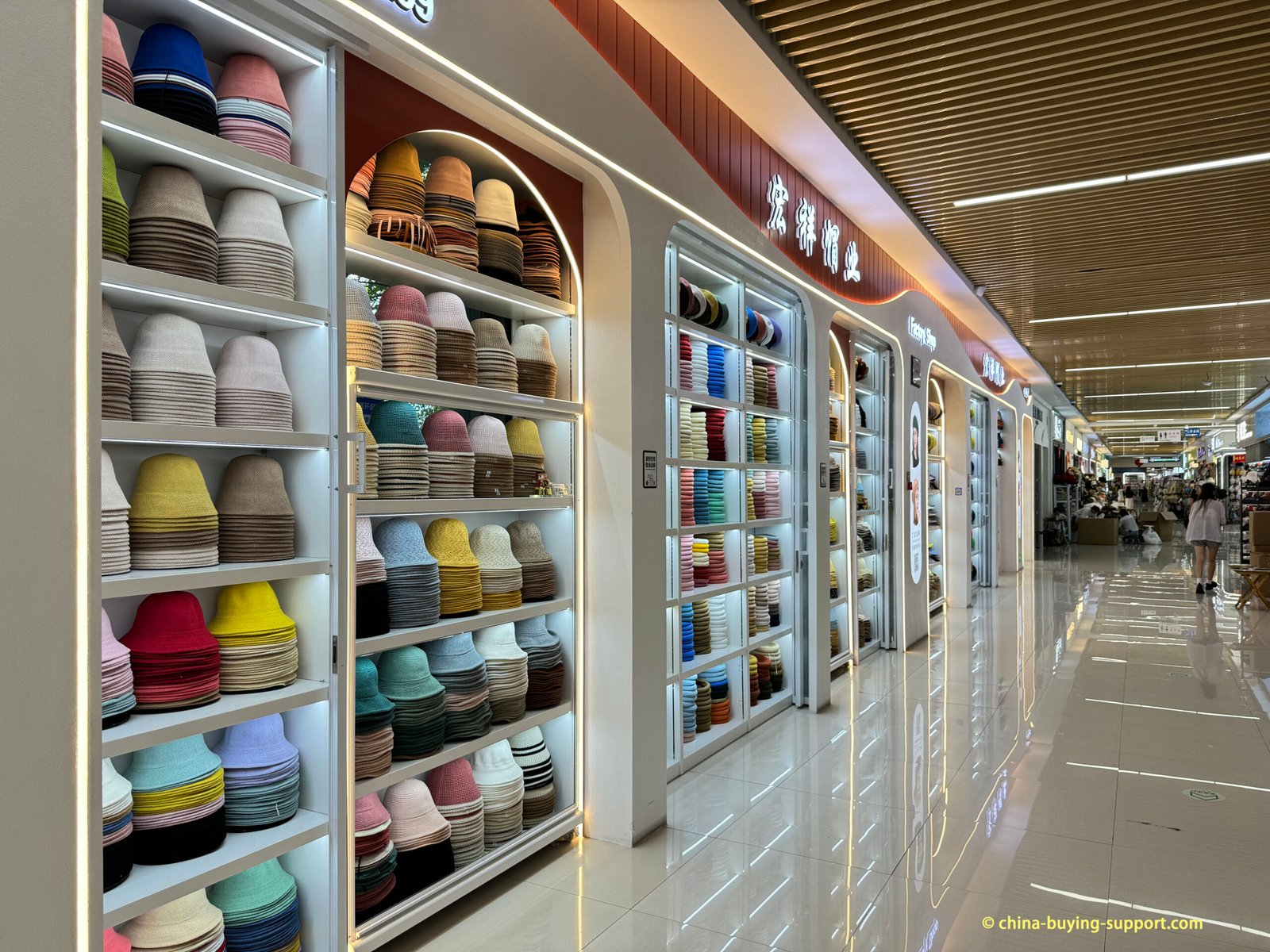 Yiwu International Trade City hat factory's showroom with floor-to-ceiling shelves of bucket hats in many colors; factory showroom in District 4