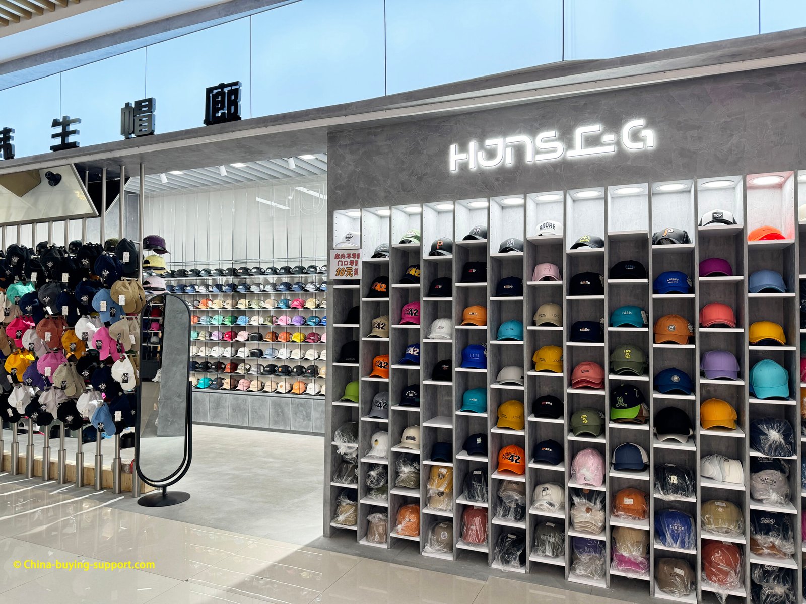 Hat factory showroom with wall-to-wall baseball caps in cubby shelves, ready for OEM/ODM wholesale orders.