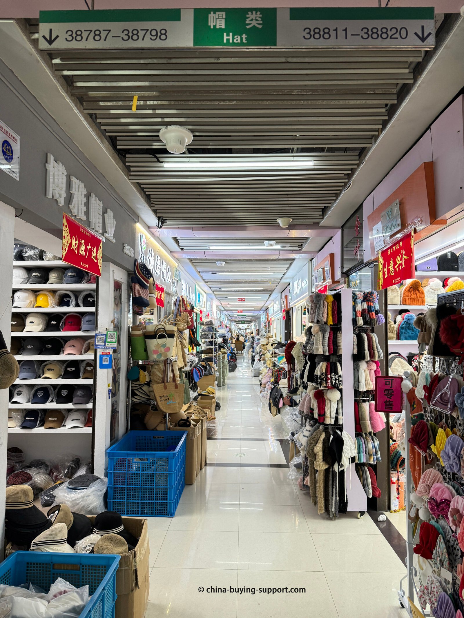 A long aisle in Yiwu International Trade City’s hat section, lined with wholesale shops selling bucket hats, baseball caps, straw hats and knit beanies