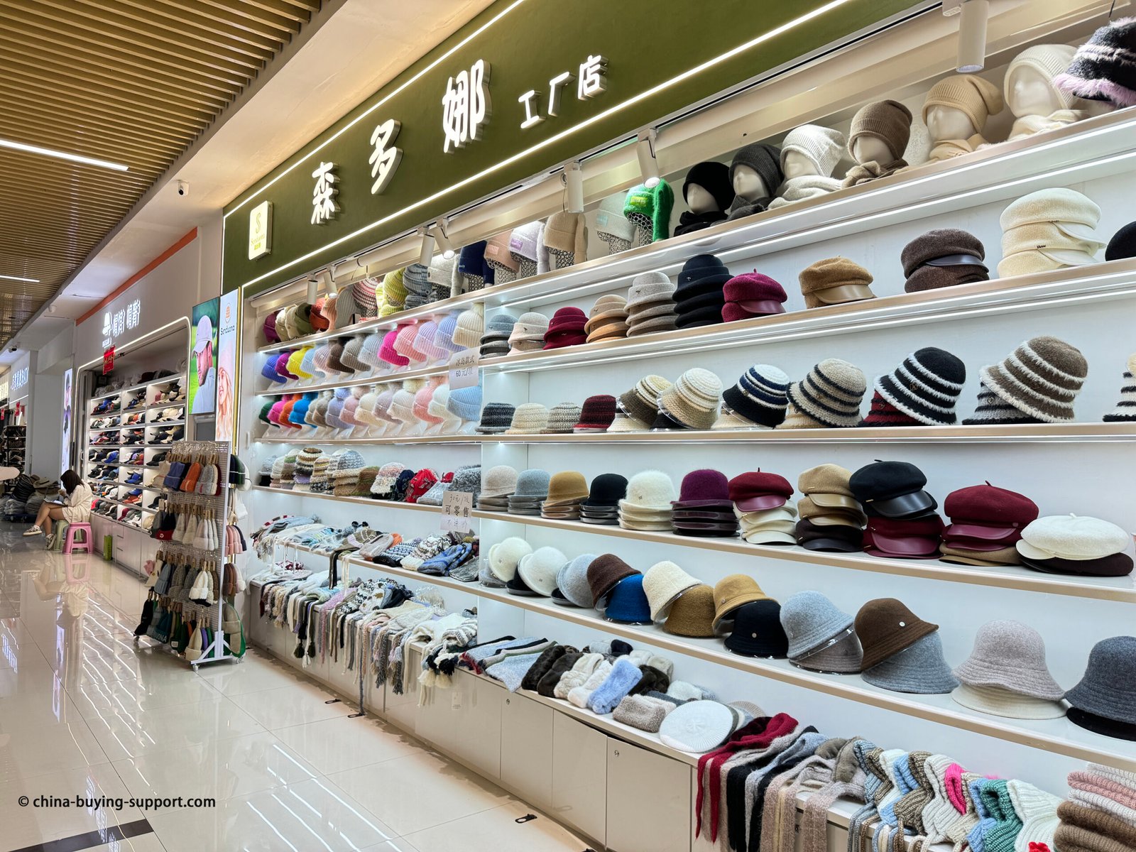 Yiwu wholesale hat shop with beanies, berets, bucket hats and scarves on display