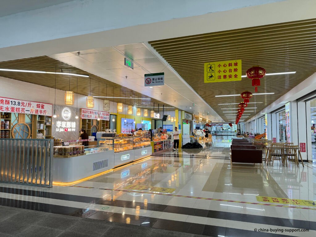 Bakery and snack counters on 2nd Floor, 18th Street (middle) of Yiwu International Trade City District 4, with coffee, pastries, red lantern décor and seating, take a rest and a cup of coffee