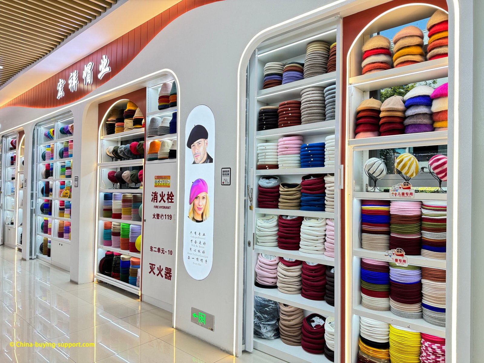 Yiwu Market wholesale beret store with walls of colorful wool berets and knit caps, Hongxiang Hat Industry, bright corridor display