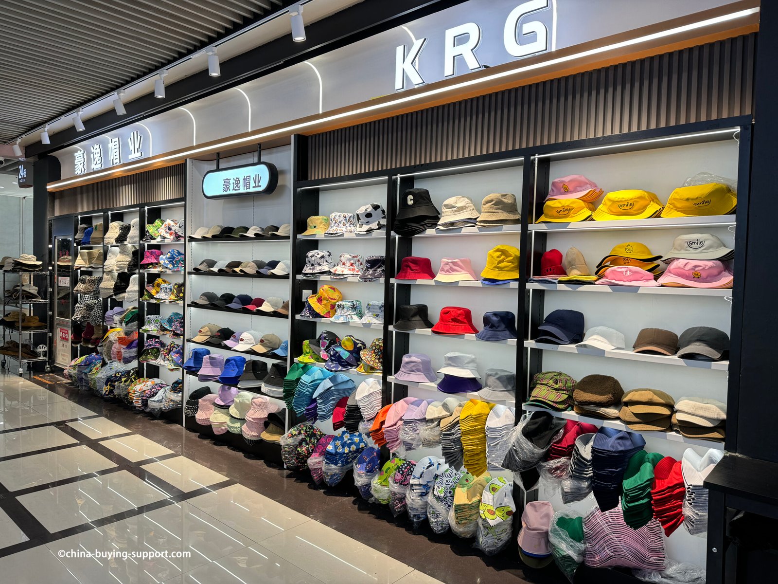 colorful bucket hats, baseball caps and visors—solid, two-tone and printed styles—neatly stacked for wholesale at the Yiwu Market hat section, China