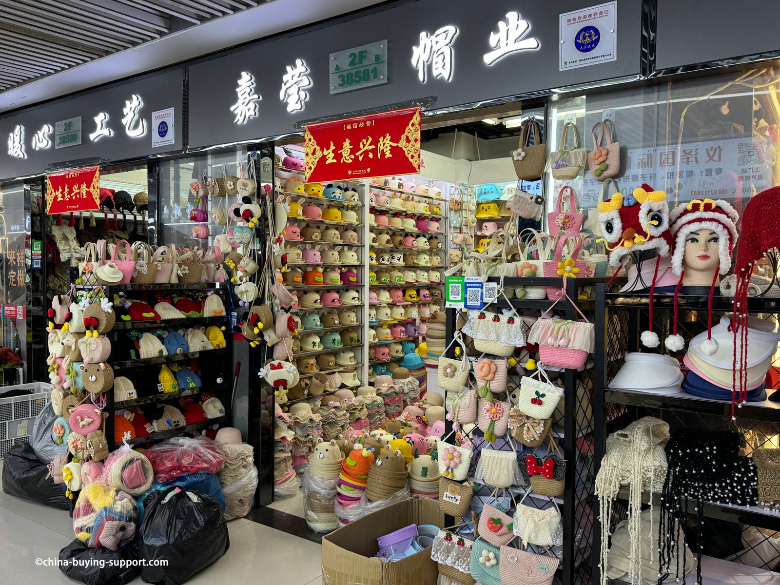 Children’s woven straw hats with cute animal faces—panda, bunny, frog, bear, pig, cat—featuring 3D ears and pastel colors on shelves in the Yiwu Market hat section, China