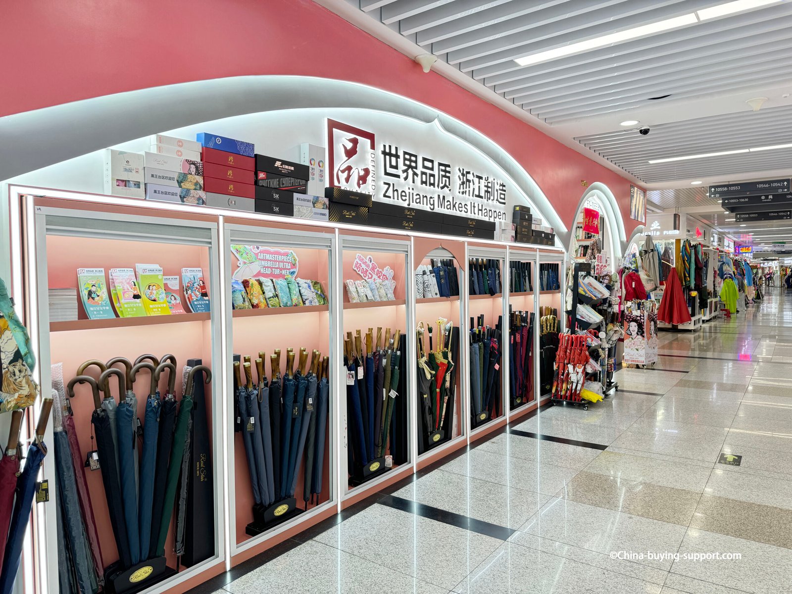 premium umbrella showroom display wall with wooden-handle long umbrellas, boxed gift sets, brand sign, Yiwu Umbrella Market