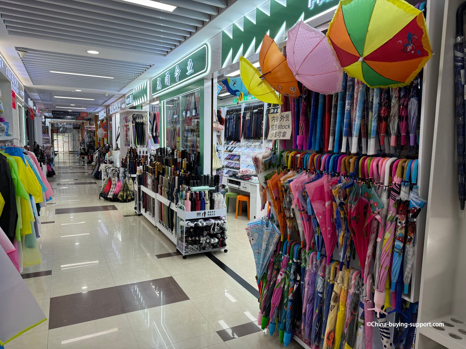 yiwu district 2 umbrella aisle with kids umbrellas, folding compact racks, hanging samples, rainwear
