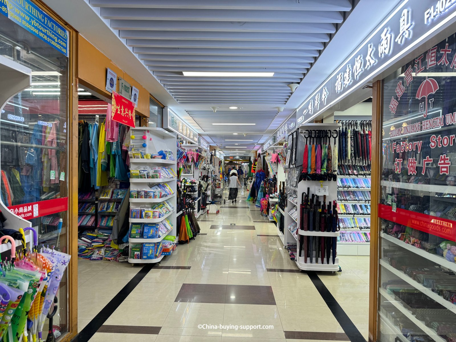 yiwu umbrella wholesale aisle with sample walls, compact and long-handle umbrellas, raincoats, shoppers