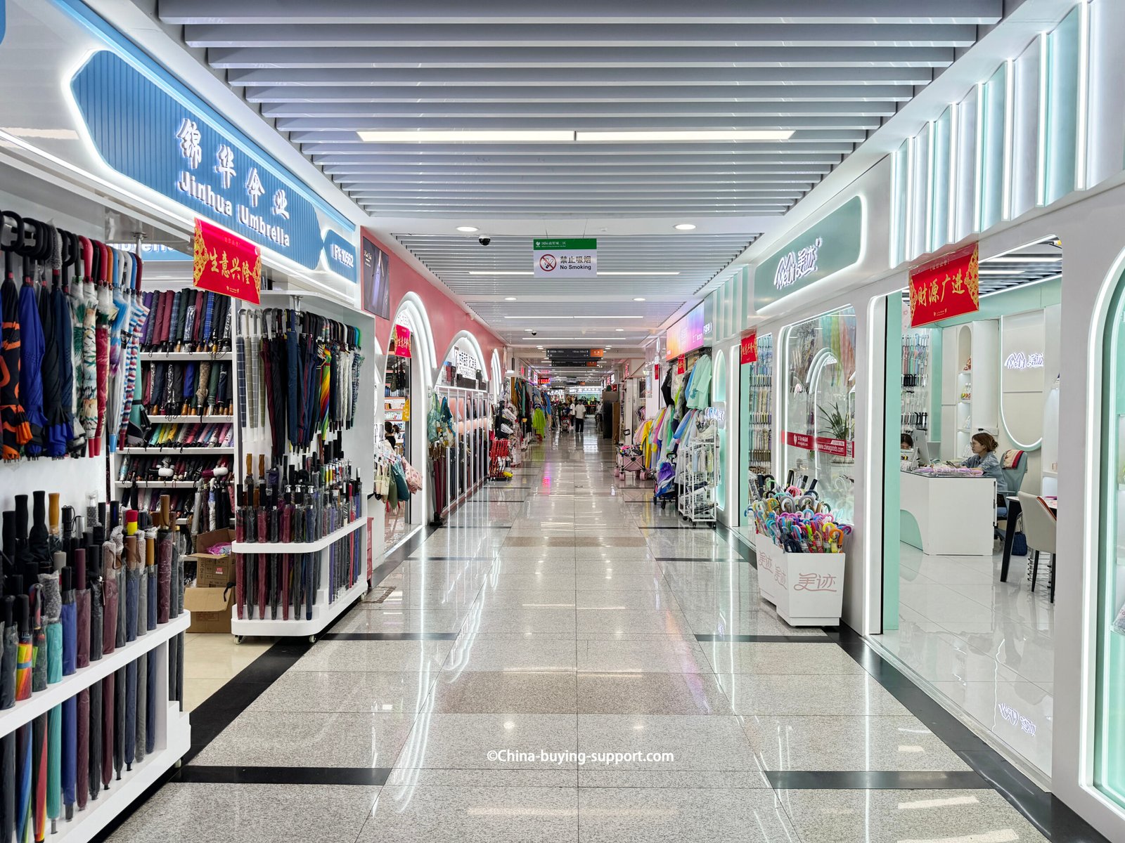 yiwu district 2 umbrella wholesale market corridor with Jinhua Umbrella storefront, long-handle racks, folding shelves, kids umbrellas bin