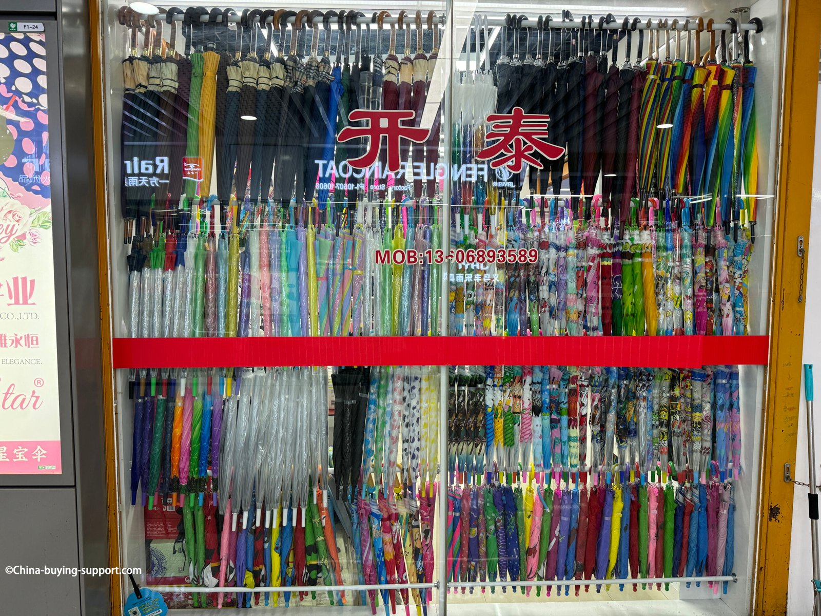 yiwu umbrella wholesale supplier's window display with clear eva canopies, kids cartoon prints, long-handle umbrellas behind glass