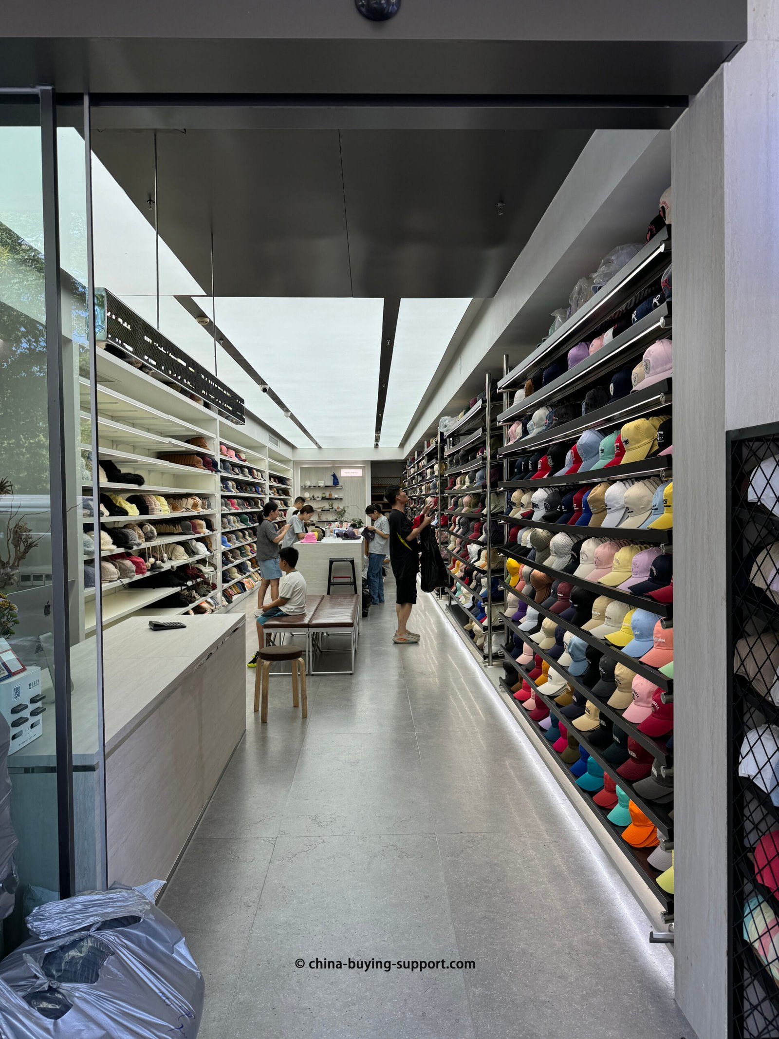 Interior of a wholesale hat shop in Yiwu, China: walls of baseball caps and knitted beanies
