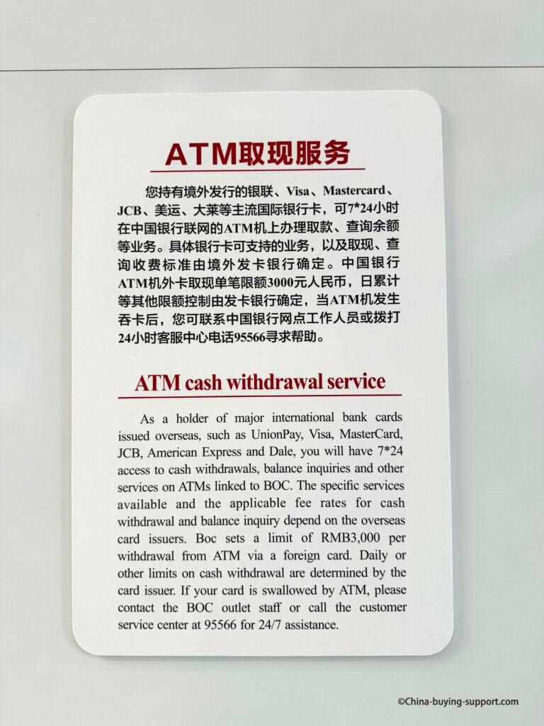 Bank of China ATM cash withdrawal service notice at Yiwu International Trade City District 2's Hall, detailing RMB 3,000 withdrawal limit, supported cards including Visa MasterCard, JCB, American Express, Dale and customer support information.