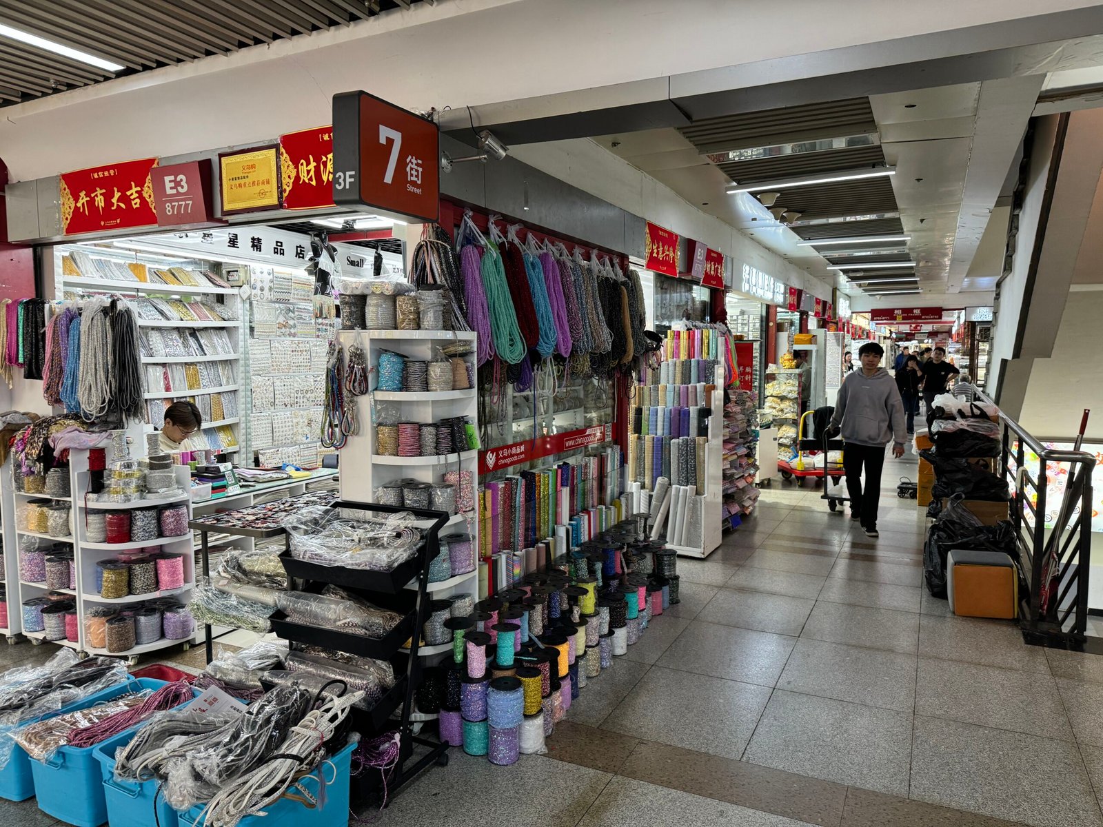 Shelves of cords, ribbons, beading thread, and rhinestone chain spools on Yiwu International Trade City 3F Section E 7th Street.