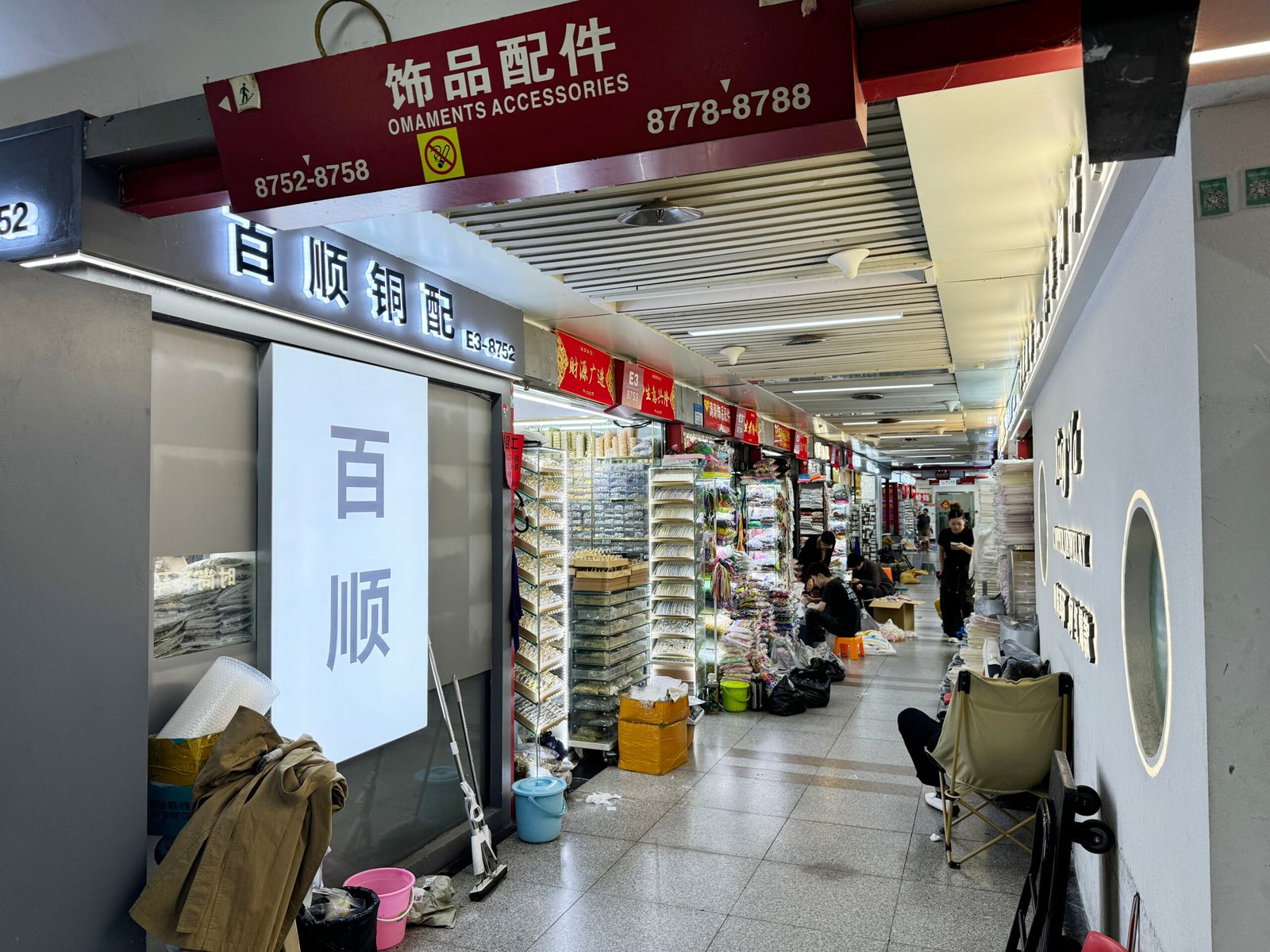 Front of a brass findings store with packed bags of jump rings, clasps, and chains in Yiwu E Area.