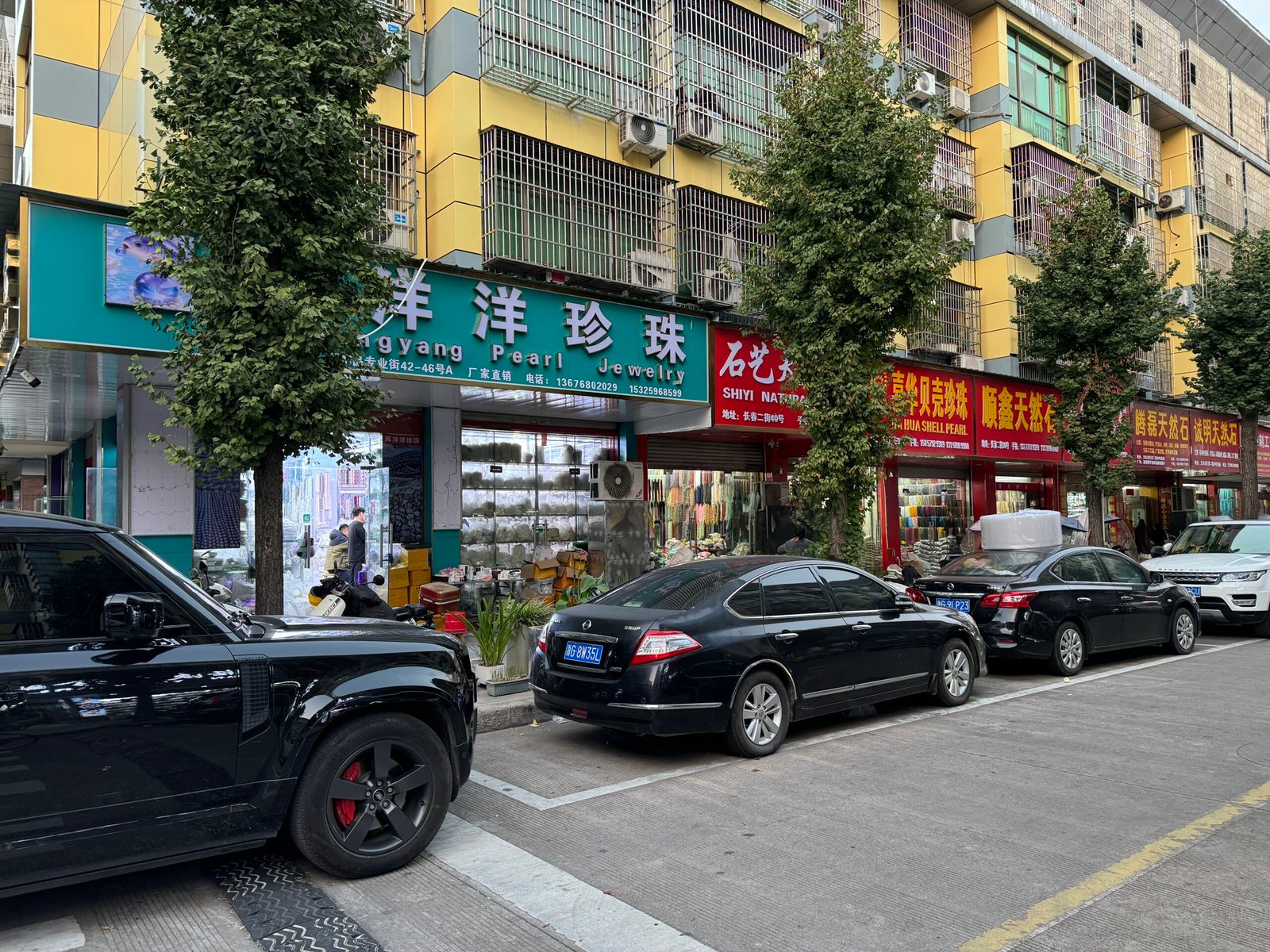 Yiwu Changchun Street row: Yangyang Pearl Jewelry, shell pearl and natural stone stores with trays of pearls and strands