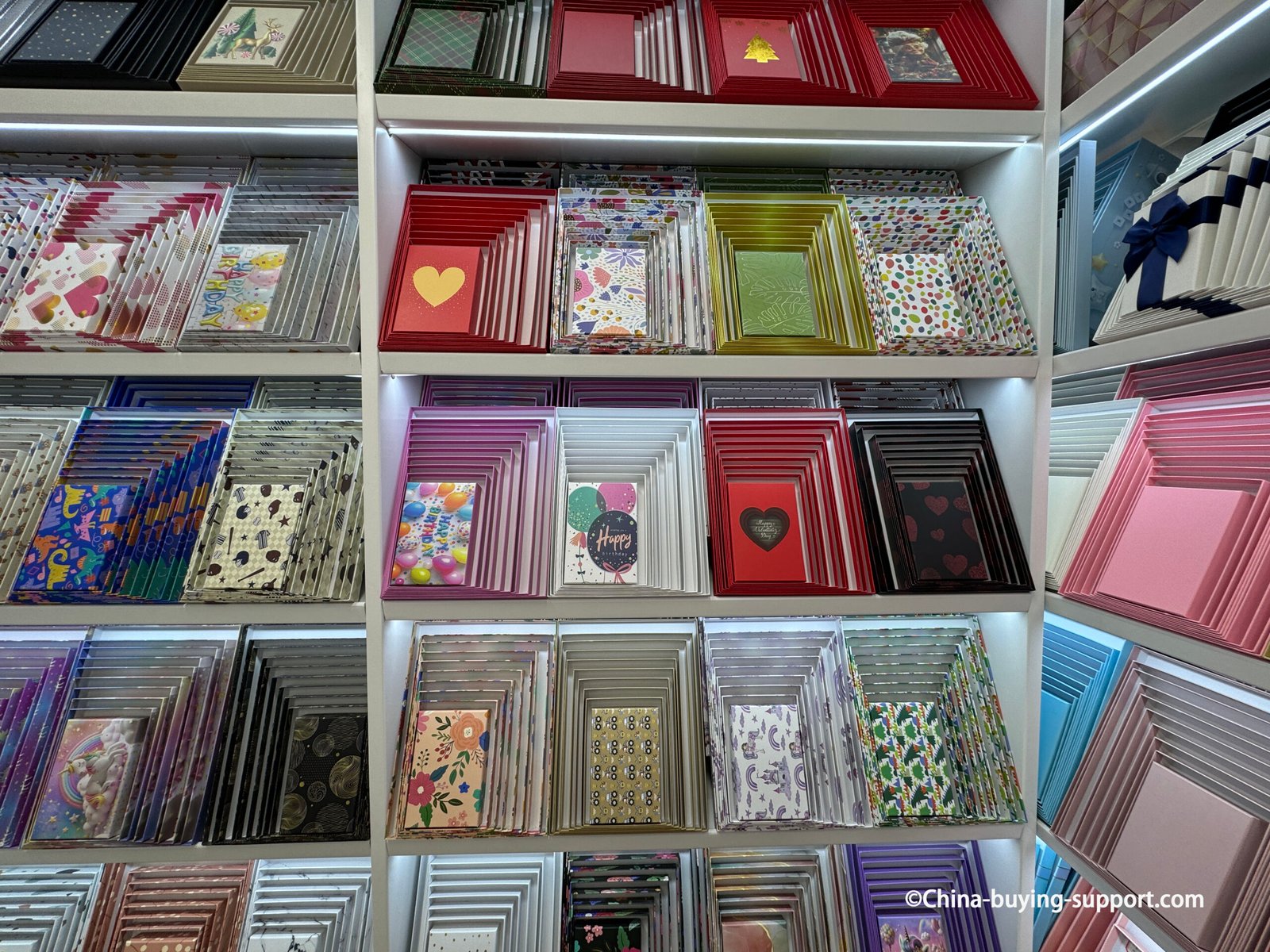 Ten-piece colorful gift box sets displayed on shelves at a packaging supplier in Yiwu International Trade City Zone 2, featuring various nesting box sizes and designs for gift and retail packaging.
