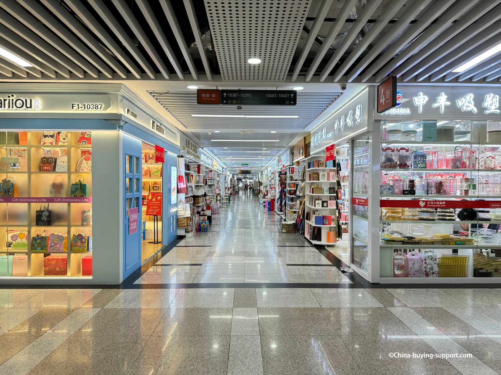 Interior corridor of Yiwu International Trade City District 2 gift packaging area with brightly lit shops displaying paper gift bags, pouch and wedding packaging decorations in China’s largest gift packaging wholesale market.
