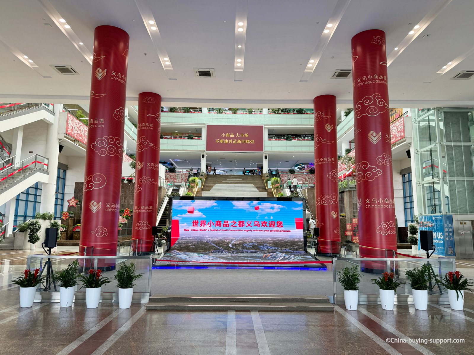 Yiwu International Trade Market District 2 interior hall near West Gate 33, featuring large red columns, LED welcome screen, and modern architecture inside the world’s largest wholesale market in Yiwu, Zhejiang, China.