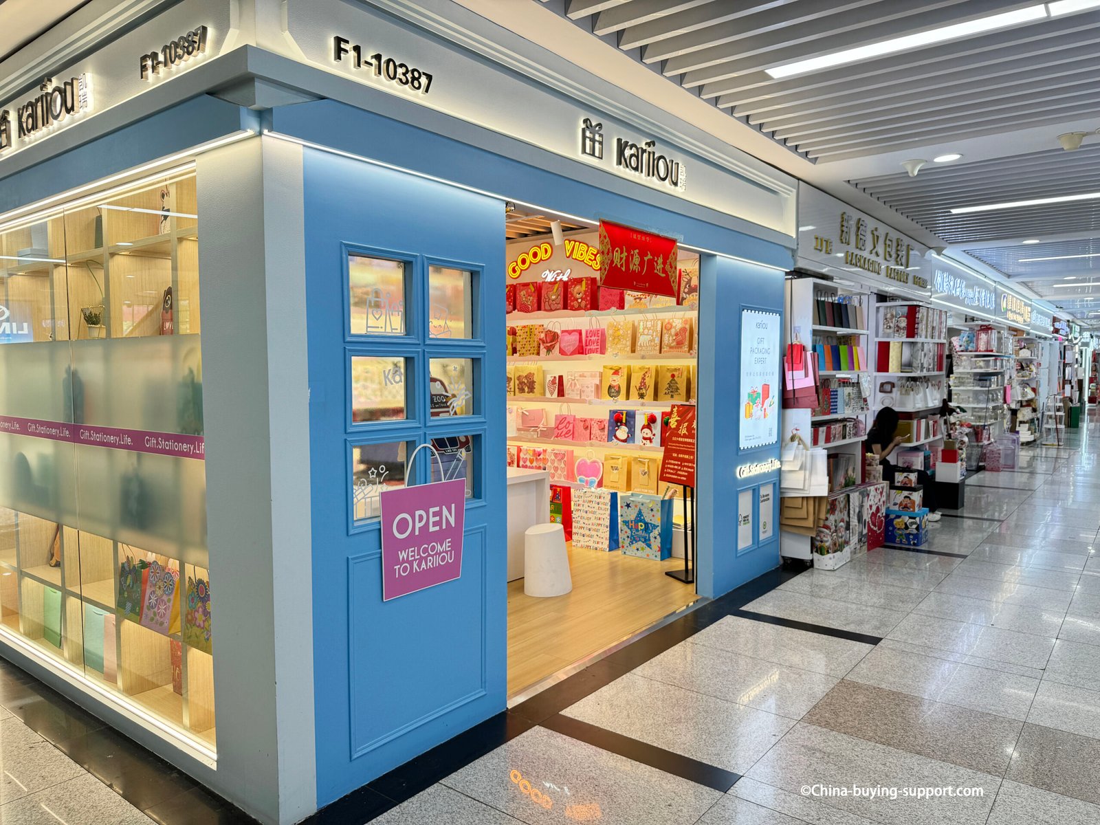 Kariou gift packaging store in Yiwu International Trade City District 2, displaying colorful paper bags, gift wrapping supplies, and stationery products for wholesale buyers.