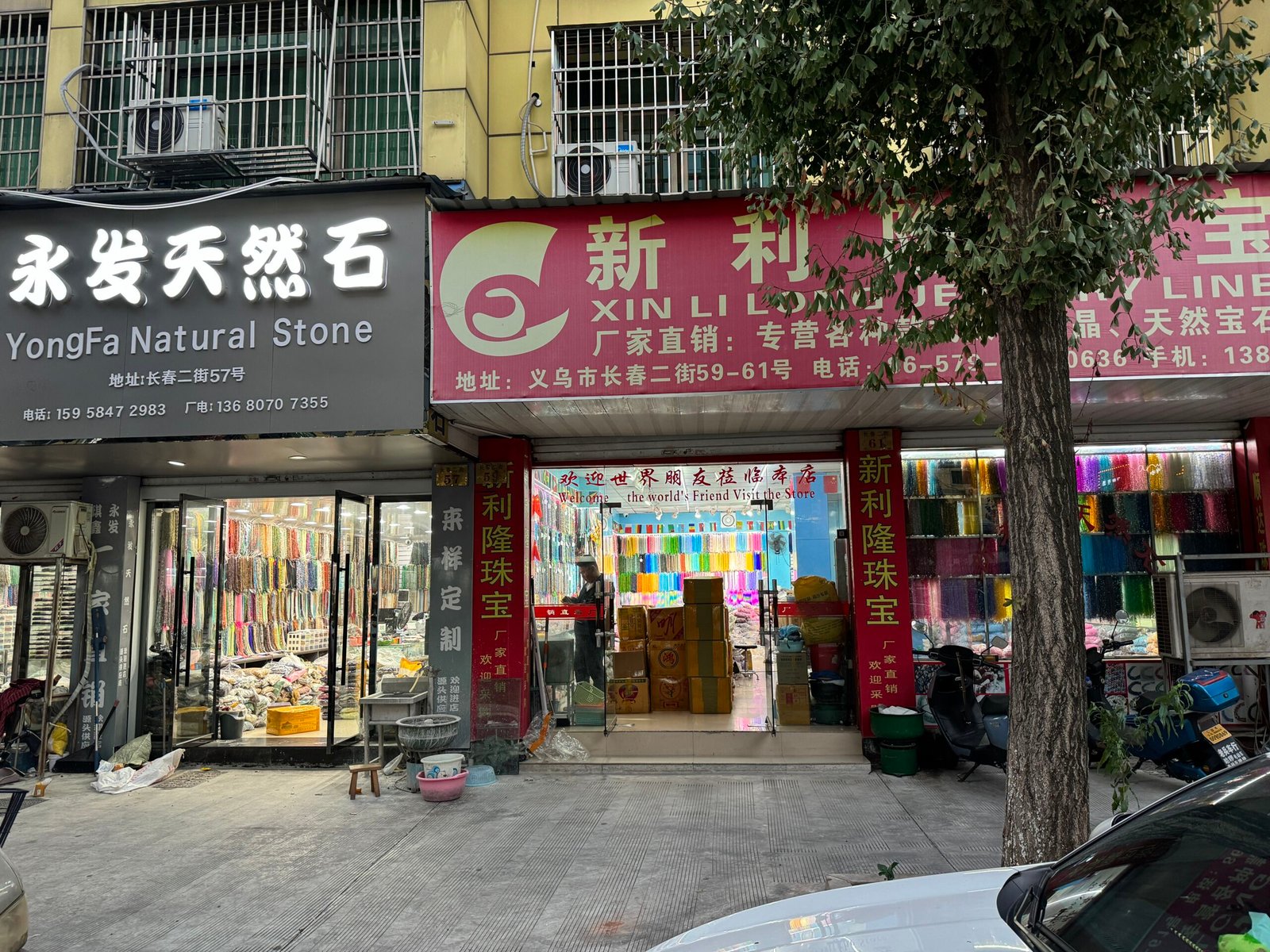 Yongfa Natural Stone and Xin Li Long storefronts; interior walls covered with colorful gemstone strands; cartons for bulk shipping; findings and packaging available.