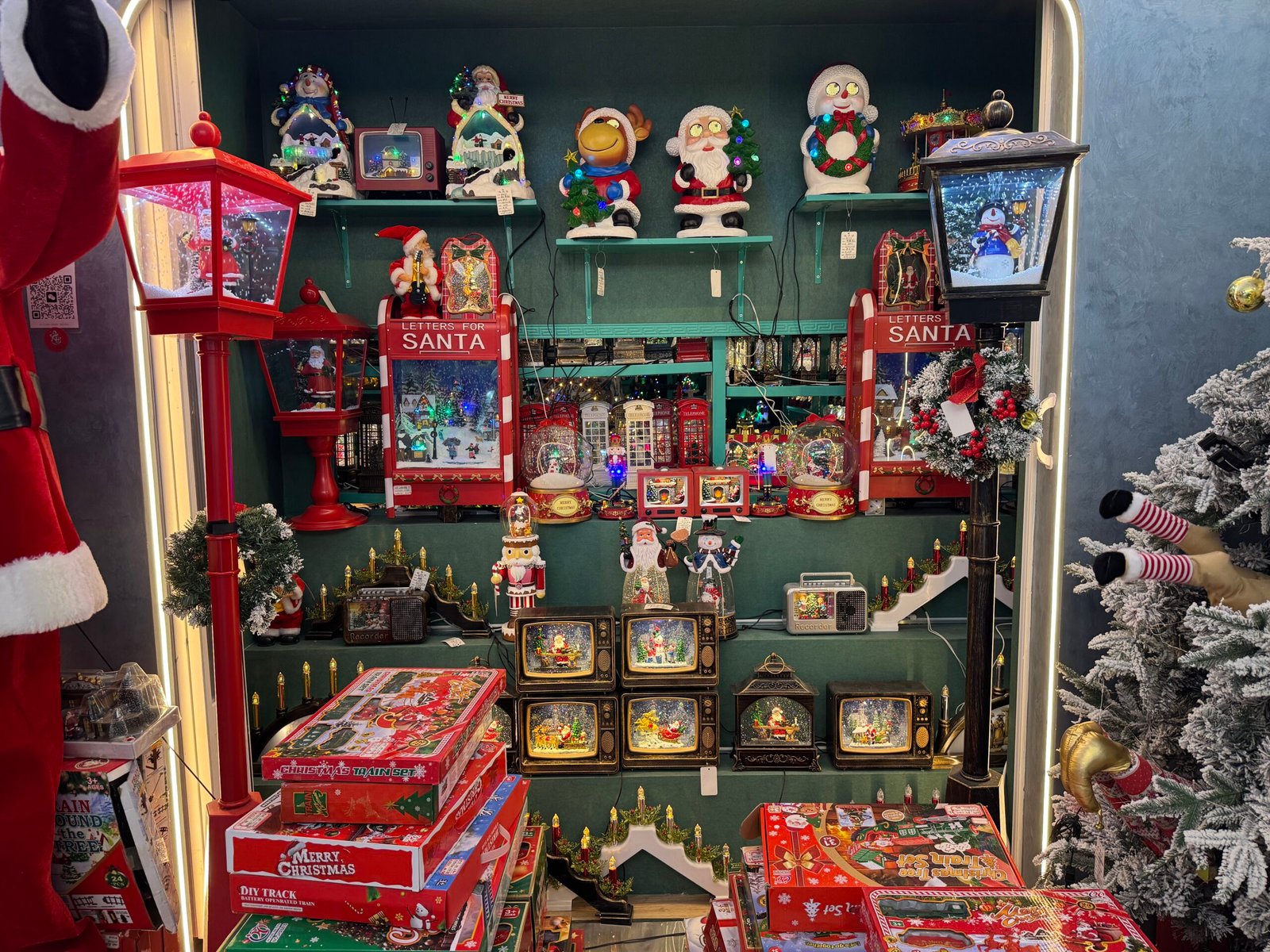 Christmas music boxes, snow globes, Santa scenes, and illuminated decorations showcased at Yiwu Christmas wholesale supplier.
