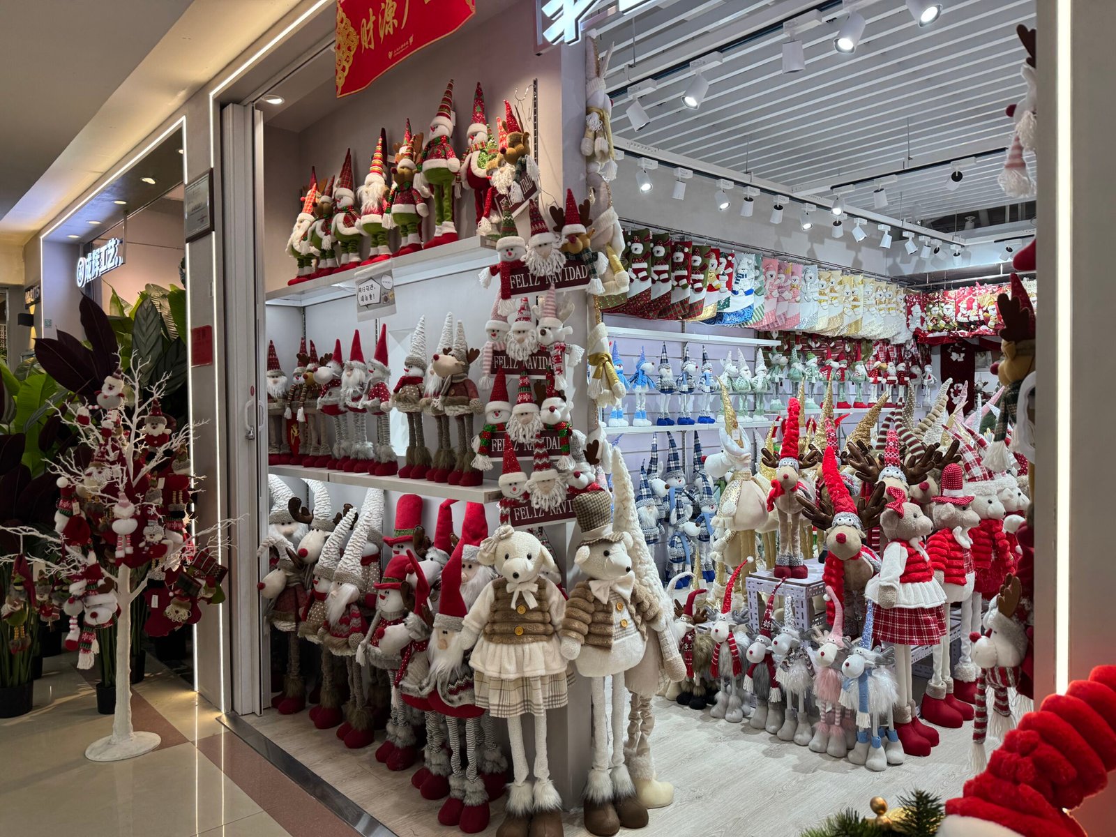 Reindeer plush dolls, Santa plush figures, gnomes, and long-legged Christmas decorations showcased at Yiwu wholesale market.