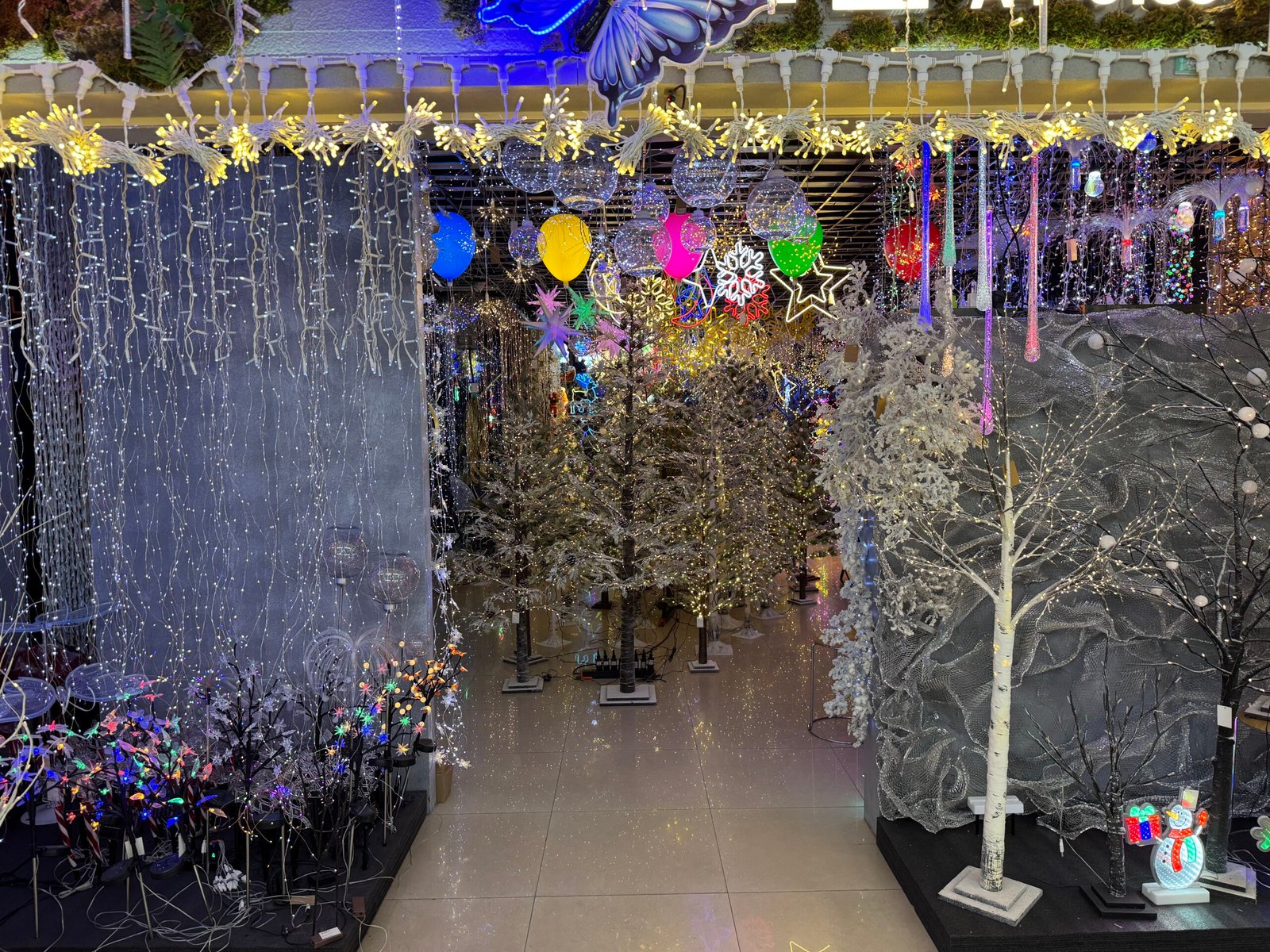 LED Christmas trees and dense string lights hanging from the ceiling and walls in a lighting booth at Yiwu Christmas wholesale market