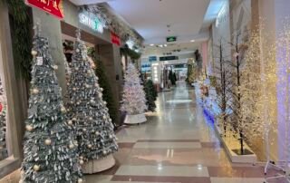 Corridor of Yiwu Christmas wholesale market with snowy artificial Christmas trees on one side and LED light trees on the other