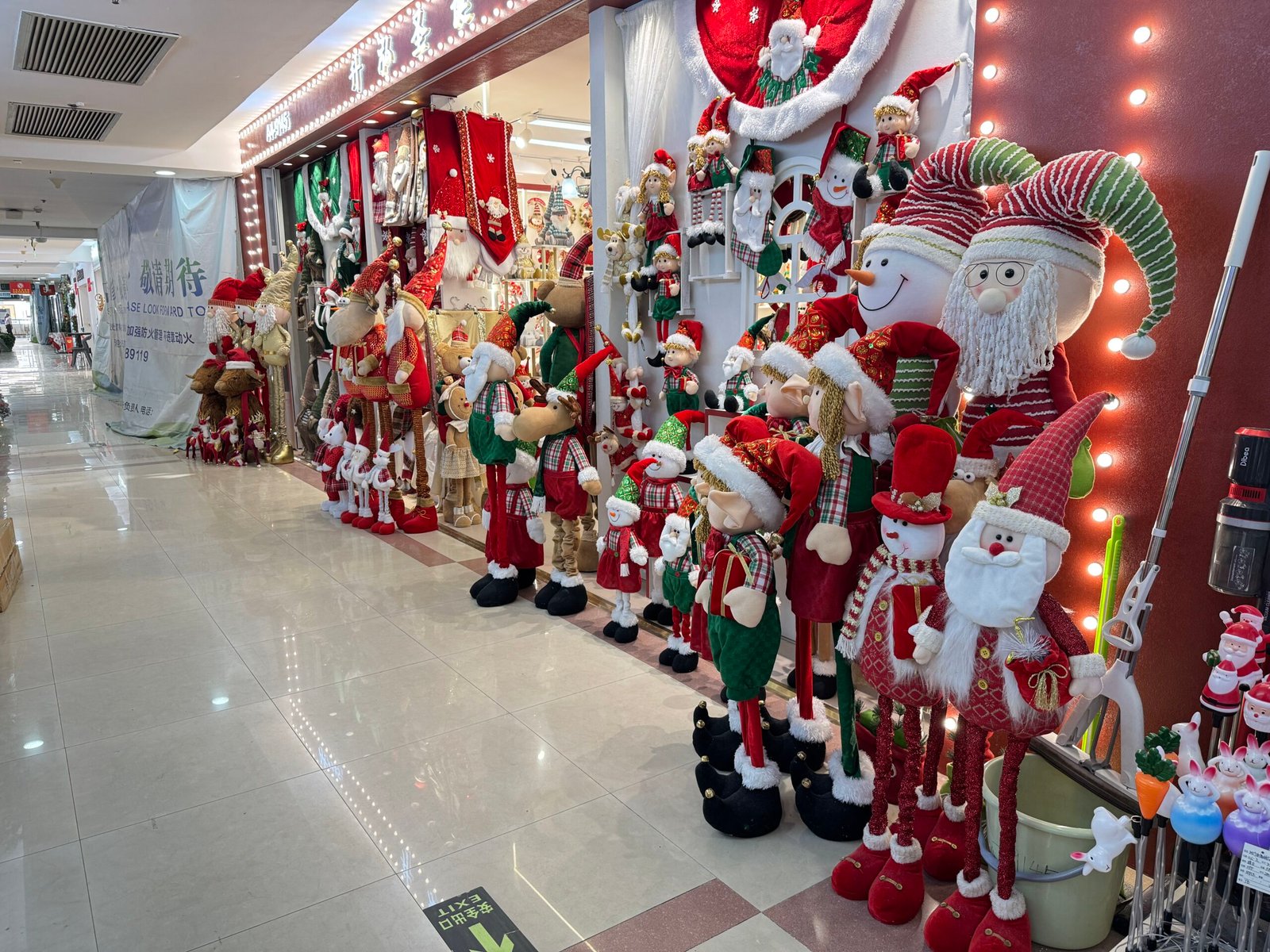 Long row of plush Santa, elf, snowman and reindeer dolls outside a Yiwu Christmas decorations shop.