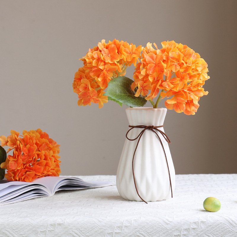 Orange artificial hydrangea flowers arranged in vase for wholesale decor