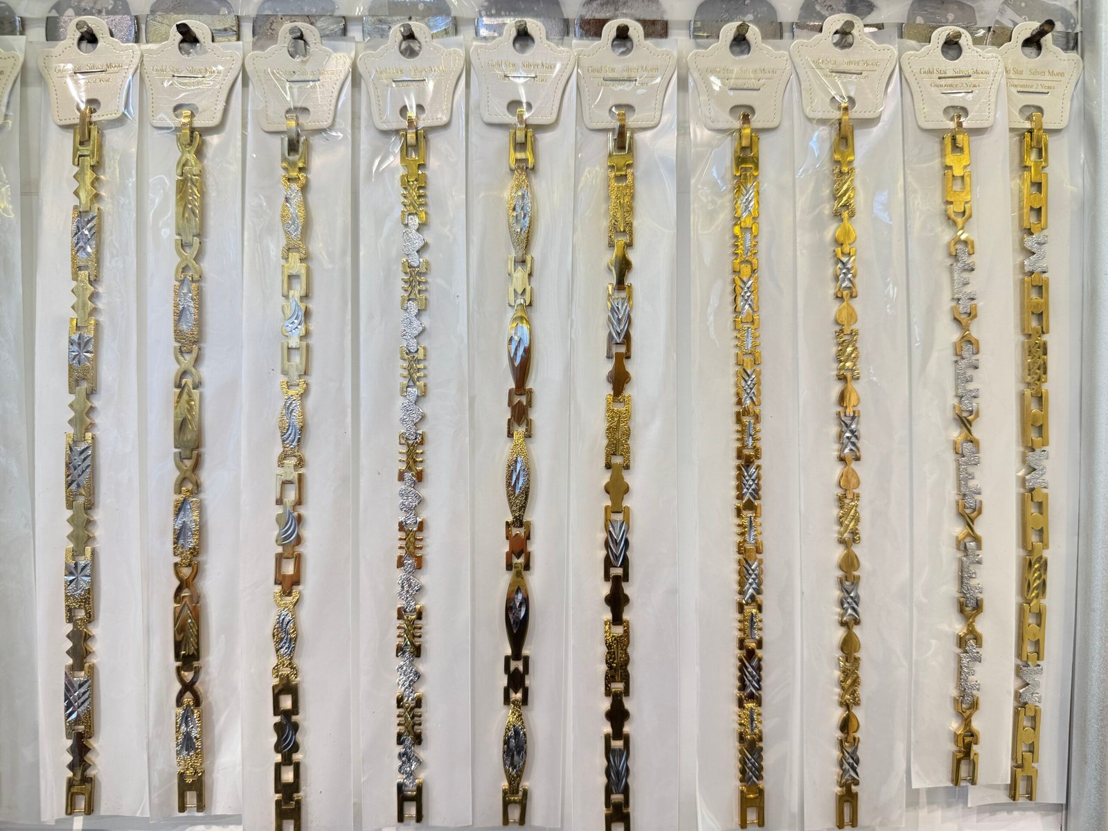 Packaged two-tone copper gold plated bracelet chains with oval center details and patterned links for wholesale, in Yiwu Market