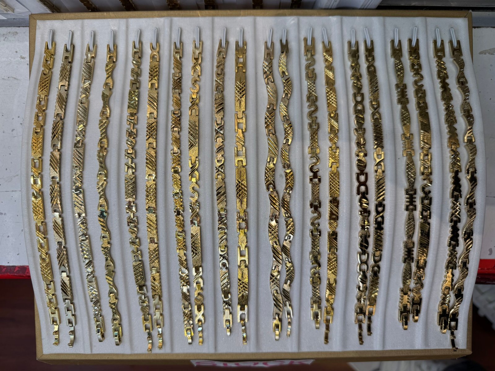 Chunky copper gold plated ID bracelet chains with wide polished plates displayed for wholesale sourcing