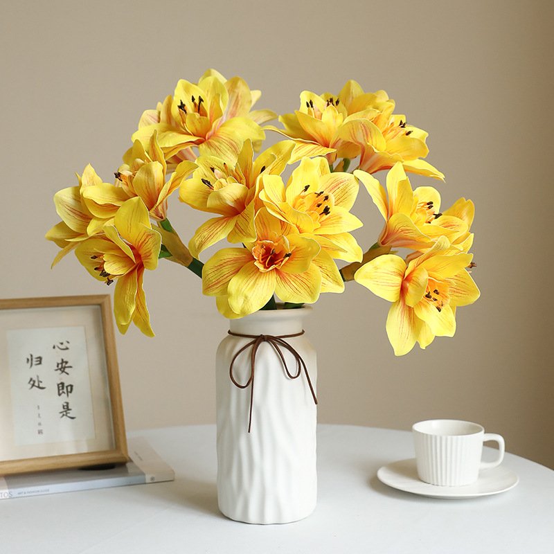 Yellow artificial lily flowers arranged in vase for decor