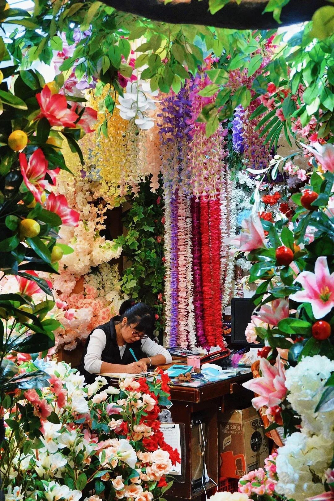 Factory shop office inside Yiwu Artificial Flower Market with hanging artificial flowers