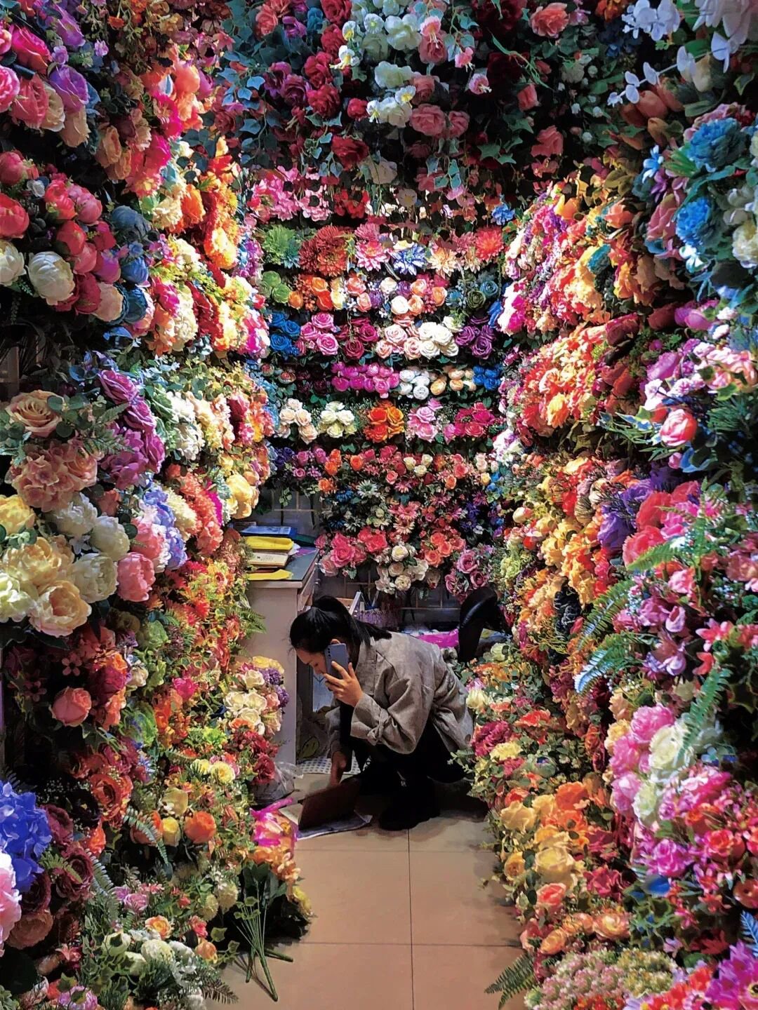 Wholesale artificial flower shop in Yiwu with staff preparing faux flower orders