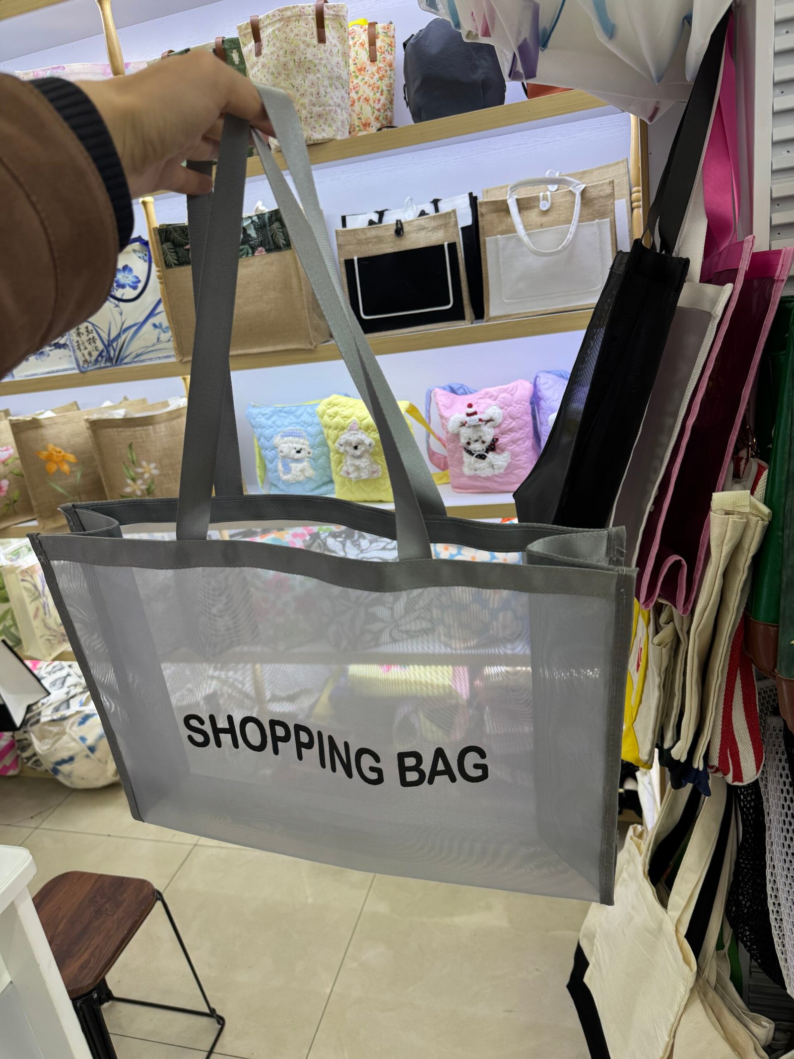 Gray custom mesh shopping bag with long handles side gusset and black logo print