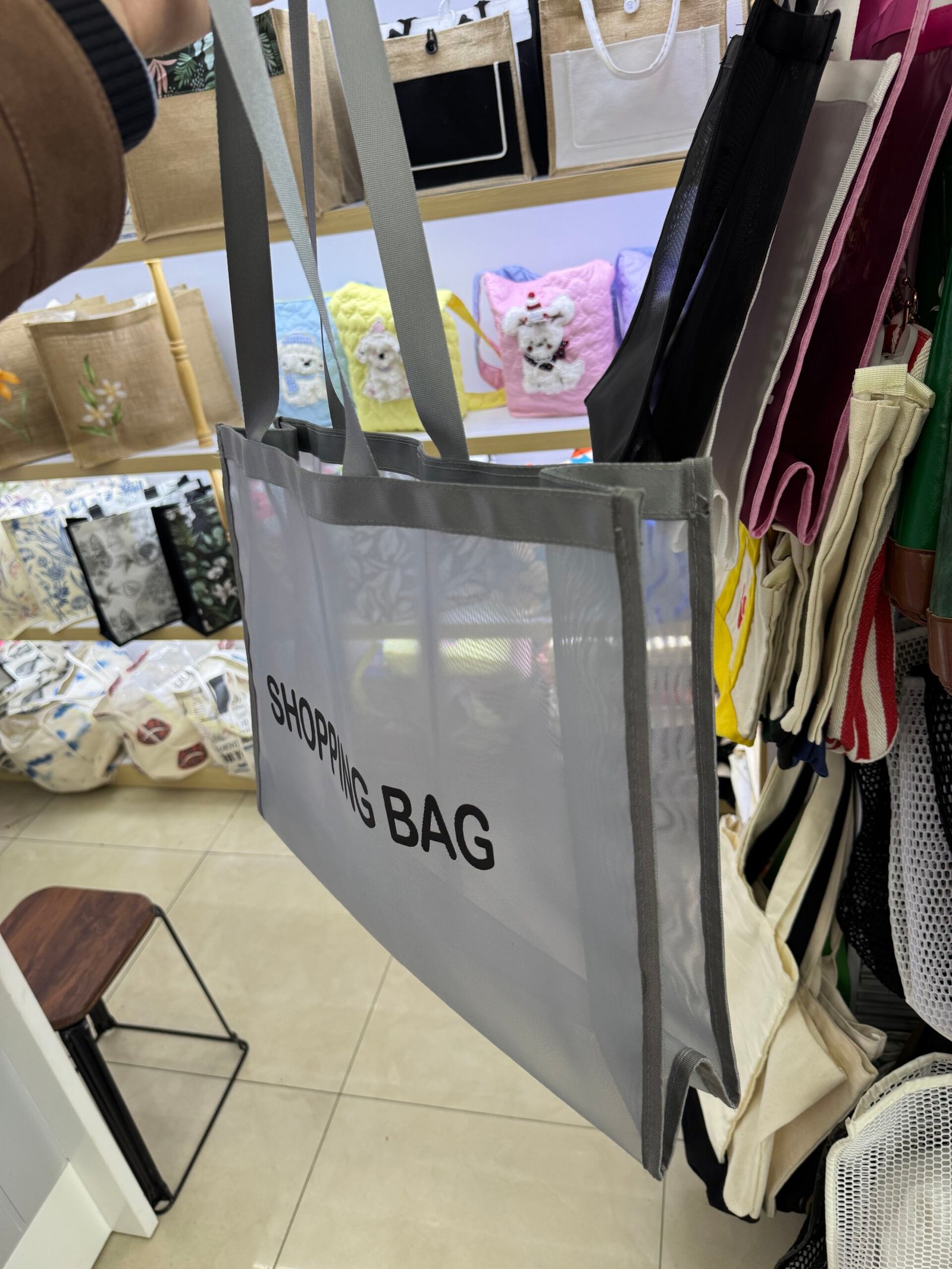 Side view of gray custom nylon mesh tote bag with gusset binding and long webbing handles