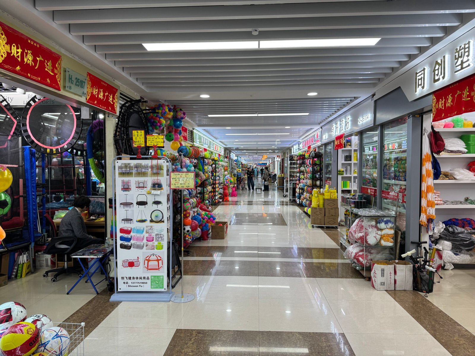 Inside Yiwu Sports Market corridor with sports goods shops on both sides