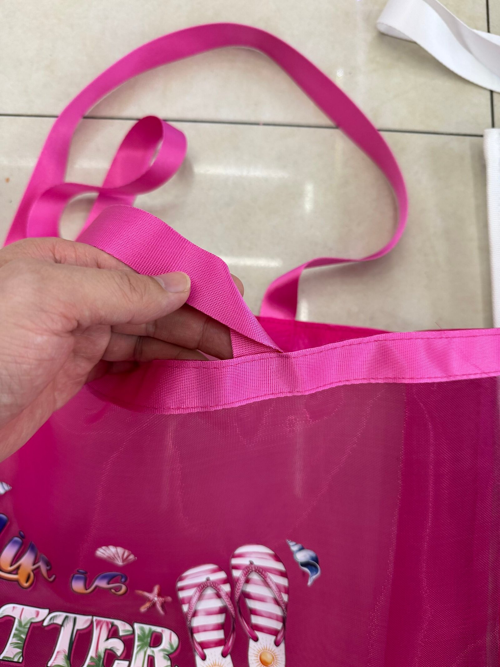 Close-up of pink custom mesh tote bag handle webbing top binding and stitching detail