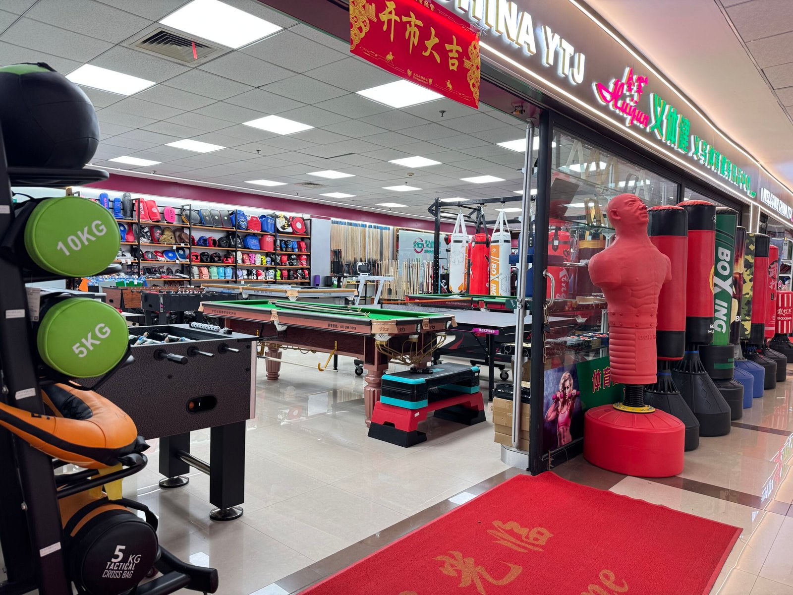 Boxing and indoor sports equipment shop in Yiwu market with punching bags and billiards tables