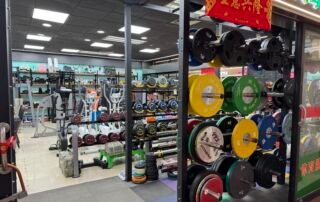 Strength training equipment shop in Yiwu market with weight plates, barbells, and dumbbells