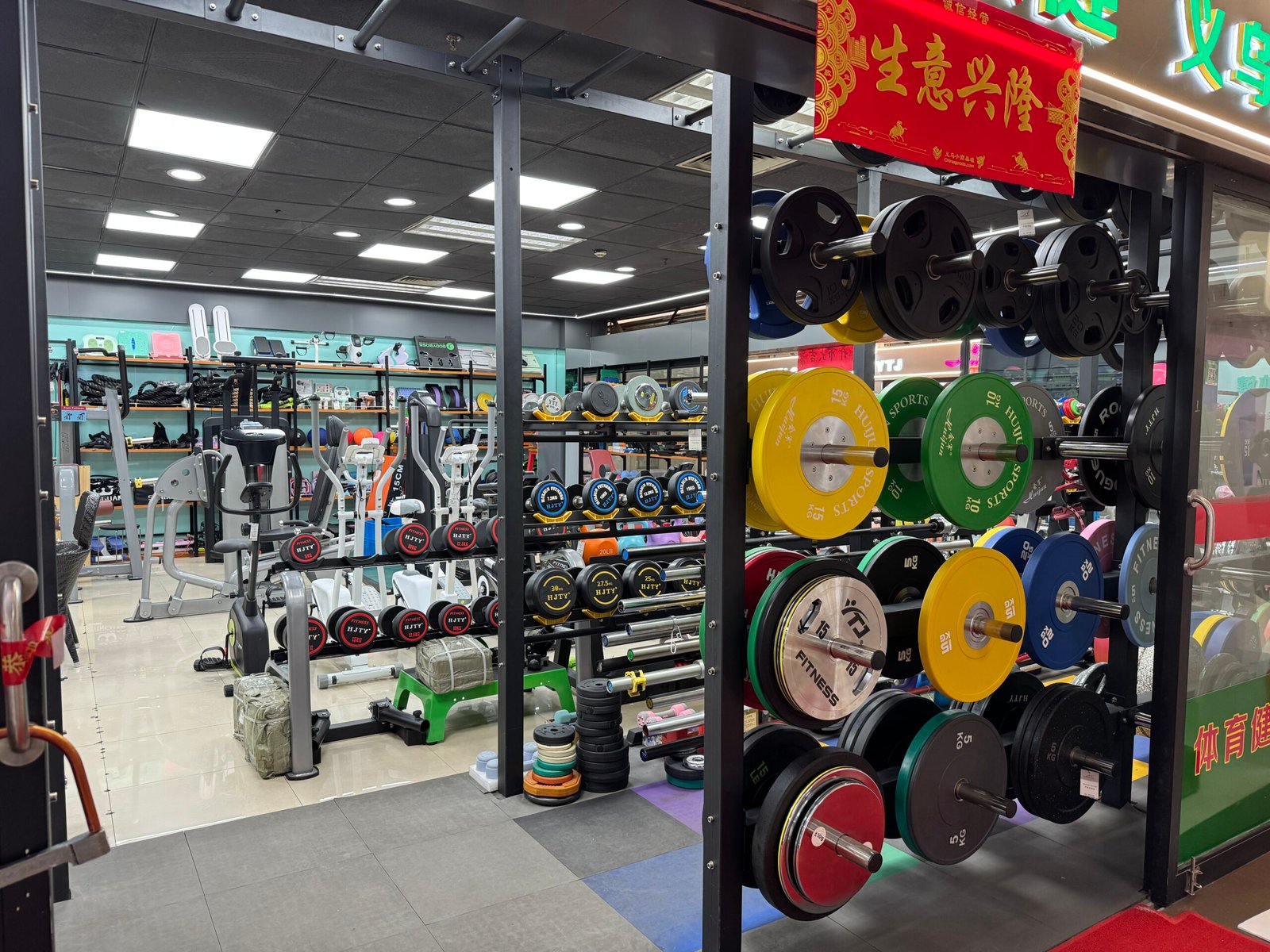 Strength training equipment shop in Yiwu market with weight plates, barbells, and dumbbells