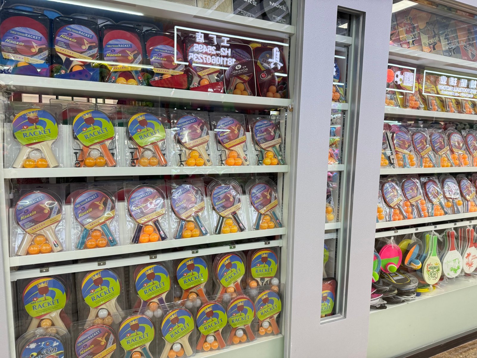 Table tennis rackets and ping pong ball sets displayed in a Yiwu Sports Market shop