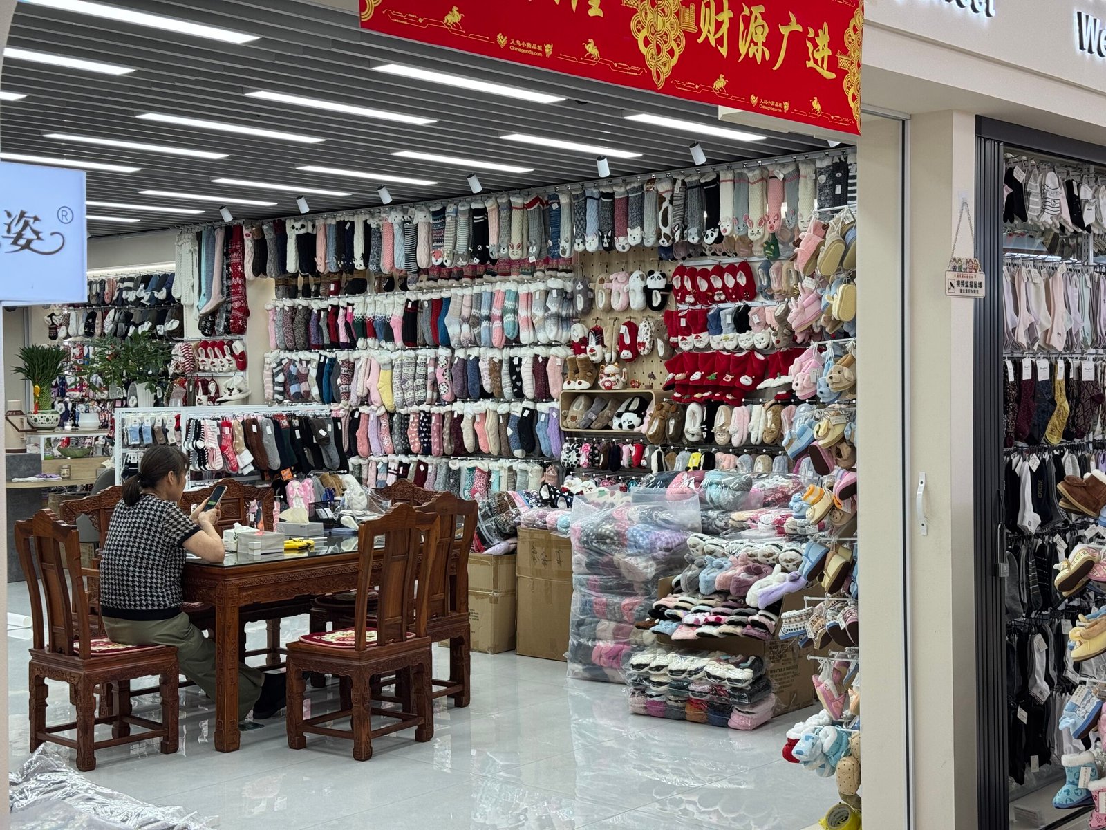 Fuzzy winter socks and plush slipper socks displayed at a wholesale shop in Yiwu, China