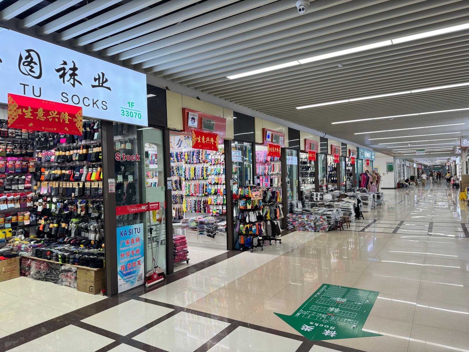 Long aisle of factory-direct sock suppliers and wholesale stores in the Yiwu sock market