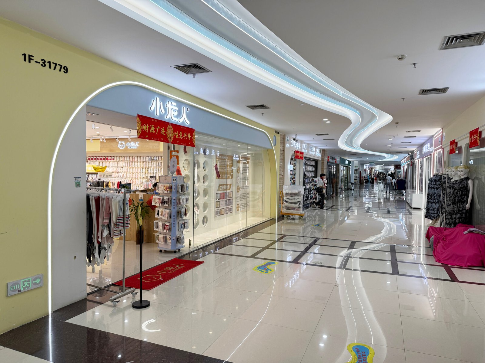Bright shopping corridor lined with wholesale sock stores inside the Yiwu socks market.