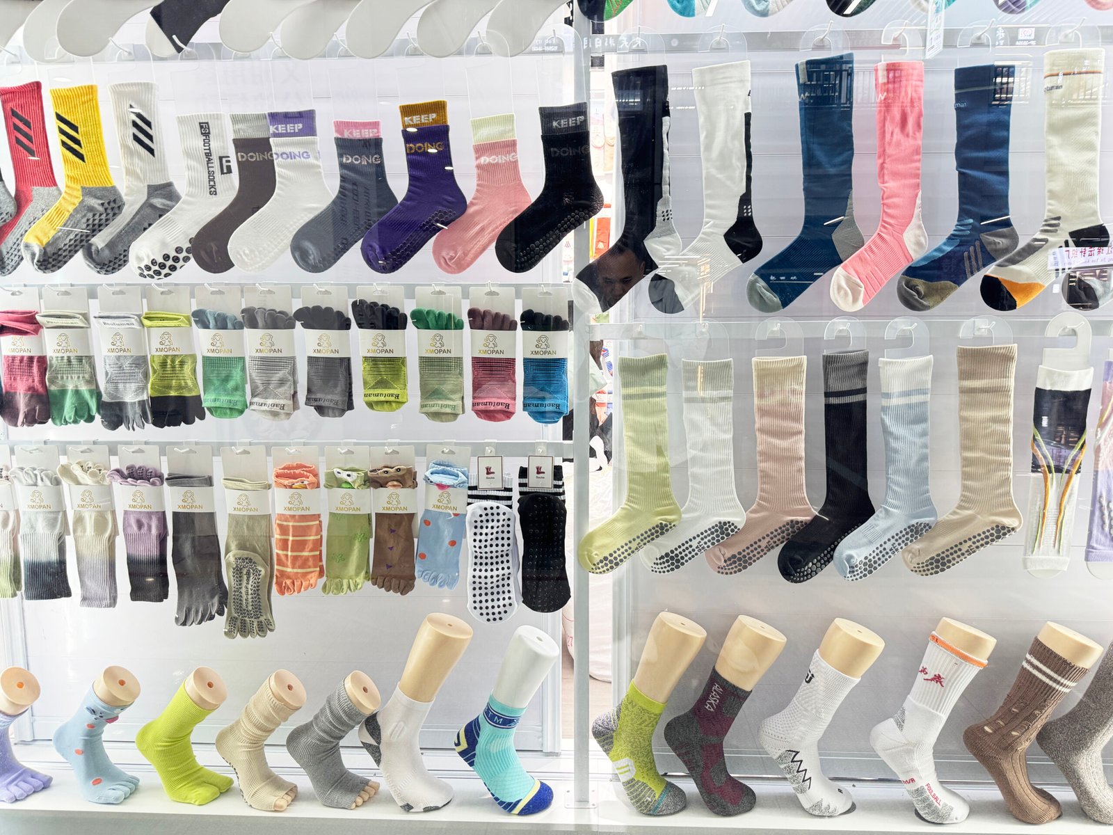 Sports socks, grip socks, toe socks, and knee-high athletic socks displayed at a Yiwu supplier
