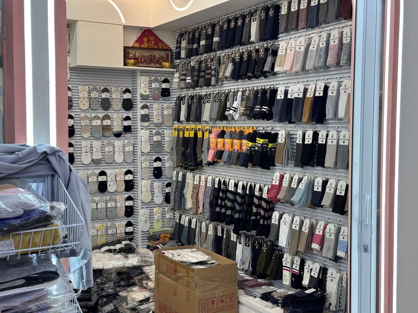 Interior of a Yiwu wholesale sock shop with rows of casual, crew, ankle, and winter socks.